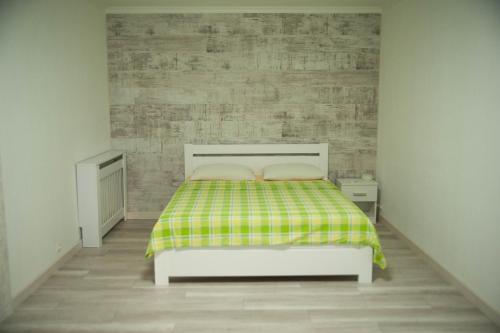 基辅Apartment FeLi House的一间卧室配有一张带绿色和黄色毯子的床