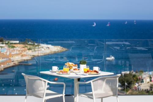 圣朱利安斯be.酒店的一张带食物盘的桌子,享有海景