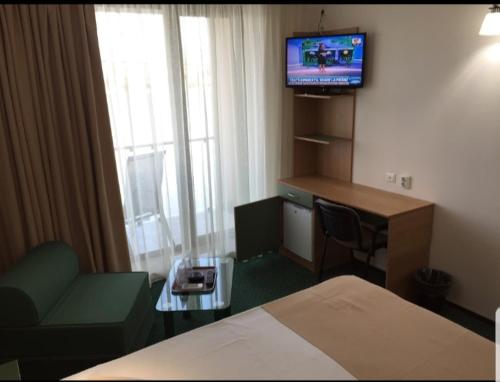 苏利纳Delta Palace的酒店客房配有一张床、一张书桌和一台电视。