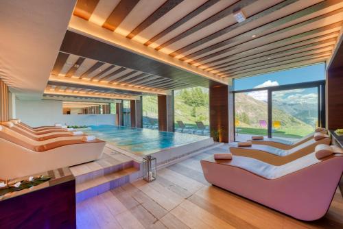 拉特乌伊莱Re Delle Alpi Resort & Spa, 4 Stelle Superior的一间带游泳池和两张沙发的客厅