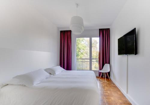 圣艾蒂安Fauriel Aimé的白色卧室设有一张大床和电视。