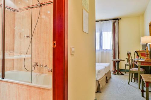 梅里达维拉达美里达酒店的酒店客房设有带浴缸的浴室和一间卧室