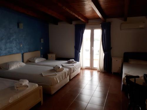 帕拉里亚拉琴Hotel Scala的一间卧室设有两张床,并设有一个通往庭院的门。