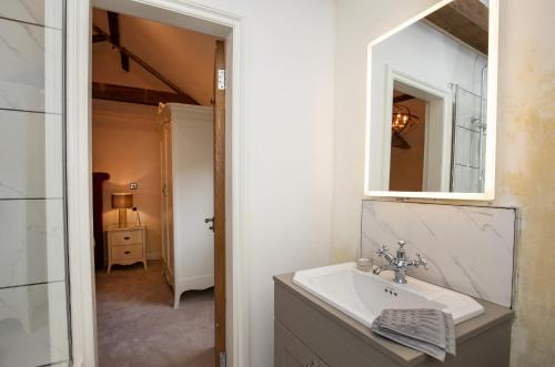 斯卡伯勒Thirley Cotes Farm Cottages的一间带水槽和镜子的浴室
