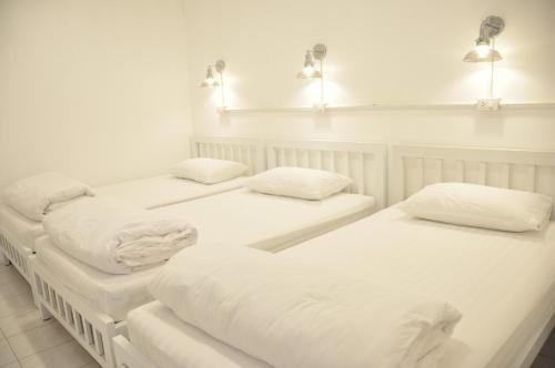 大城Zleepinezz Hostel的配有2张床的带白色床单和枕头的客房