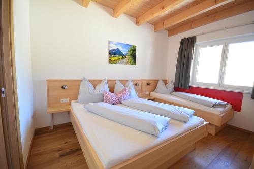 加尔蒂Chalet Gonda inklusive Premiumcard的带2扇窗户的客房内的2张床