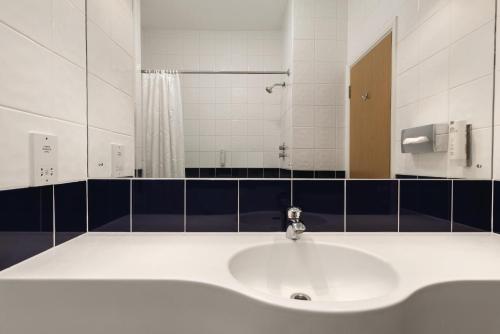 达宁顿堡Days Inn by Wyndham Donington的浴室设有白色水槽和镜子