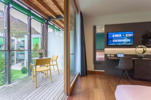 特伦托Habitat Guest House的客房设有带桌子和电视的阳台。