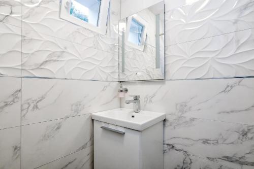 普契什查Holiday home Beyla的白色的浴室设有水槽和镜子