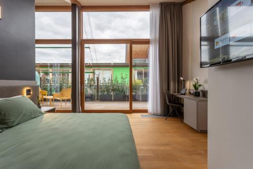 特伦托Habitat Guest House的一间卧室设有一张床和一个大窗户