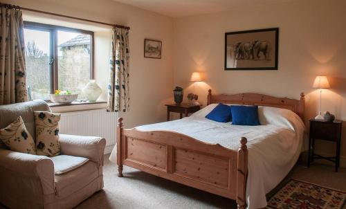谢菲尔德Loadbrook Cottages的卧室配有床、椅子和窗户。