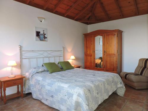 洛斯·亚诺斯·德·阿里丹Casas Las Papayeras, en Los Barros的一间卧室配有一张大床和一把椅子