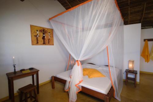 Ambaro萨姆巴特拉住宿加早餐旅馆的一间卧室配有一张带蚊帐的床