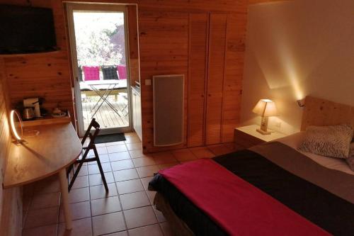 LiaussonStudio 22 m2, terrasse vue montagne, dans propriété face au Lac du Salagou的一间卧室配有一张床、一张书桌和一个窗户。