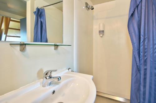 皇后镇里维斯旅馆的浴室设有水槽和蓝色的浴帘
