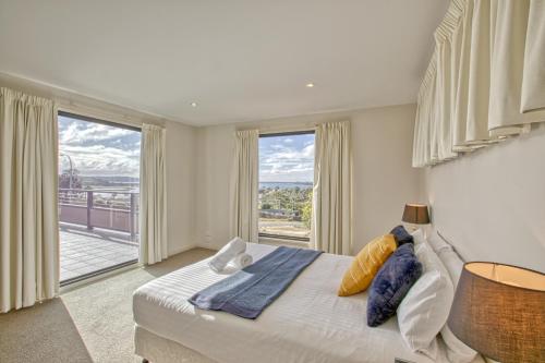 圣海伦斯Georges Bay Luxury的一间卧室设有一张床和一个大窗户
