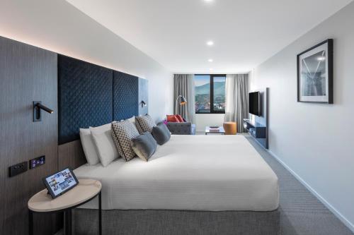 堪培拉Deco Hotel Canberra的卧室配有一张白色的大床和一张沙发。