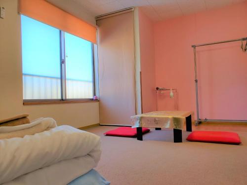 直岛町雅多七海滩酒店的一间配有沙发、一张桌子和两个窗户的客房
