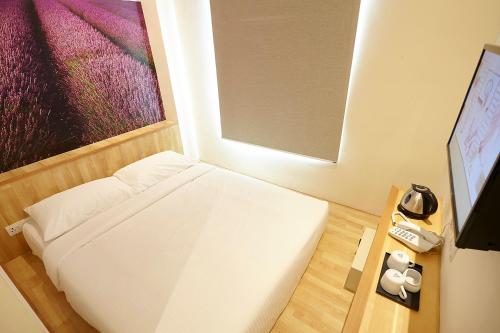 吉隆坡中谷六季酒店 的小房间设有床和电视