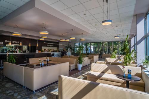 库瑞尼卡慕斯卡Hotel *** NAT Krynica Morska的餐厅配有沙发、桌子和植物