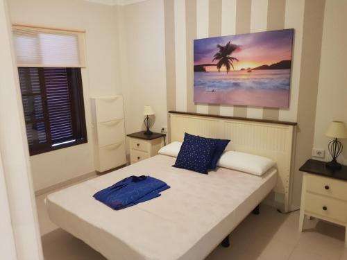 阿罗纳Residence balcon del mar的卧室配有一张床,墙上挂有绘画作品