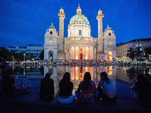 维也纳Operngasse-Karlsplatz的一群人坐在大楼前