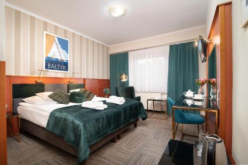 弗瓦迪斯瓦沃沃Hotel Rejs的配有一张床和一张书桌的酒店客房