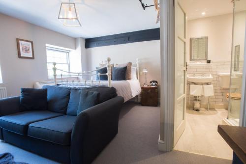 牛津前河酒店的一间卧室配有蓝色的沙发和一张床