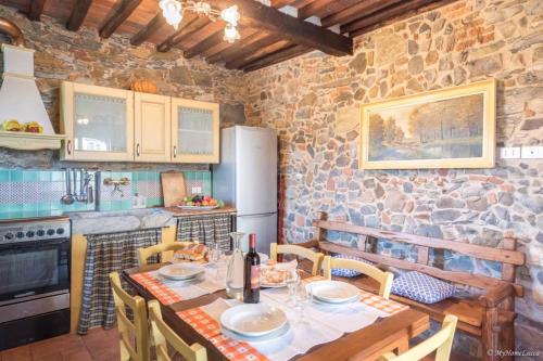 卢卡Alla Bella Aurora with Amazing POOL in Tuscany的厨房配有桌椅和石墙