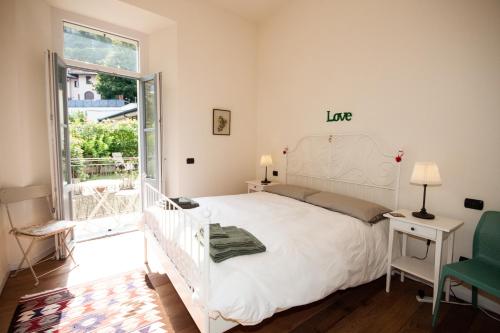 梅纳焦Casa Julia的卧室配有白色的床和绿色椅子