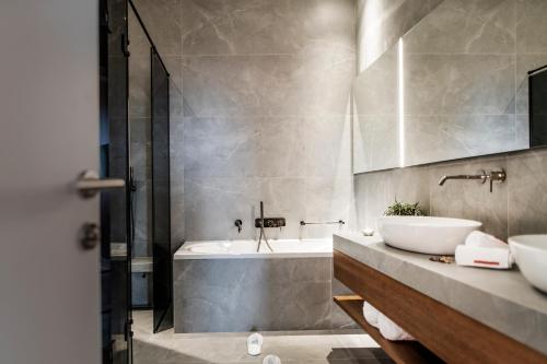 杜布罗夫尼克杜布若维尼克宫殿酒店的浴室配有两个盥洗盆和浴缸。