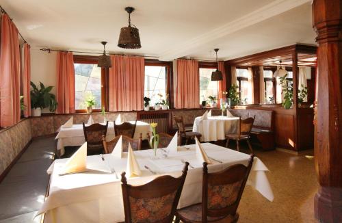 Mainhardt兰德加斯托夫索纳尔酒店的餐厅设有白色的桌椅和窗户。