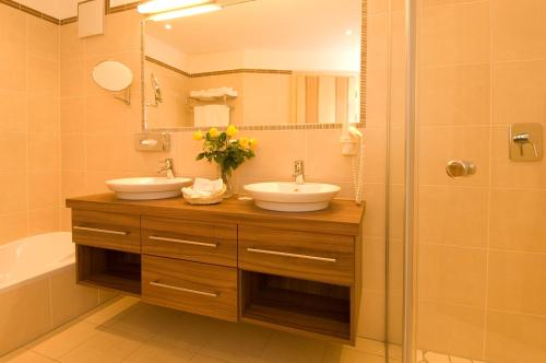 埃尔瓦尔德阿尔卑公馆度假酒店的一间带两个盥洗盆和淋浴的浴室