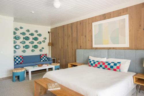 哈勃岛金沙珊瑚酒店的卧室配有白色的床和蓝色的沙发