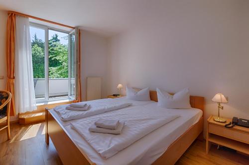 马瑟尔贝格Hotel Haus Oberland的窗户客房内的一张大白色床