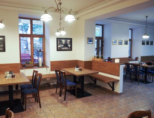 克日沃克拉特Hotel Sýkora的餐厅设有木桌、椅子和窗户。