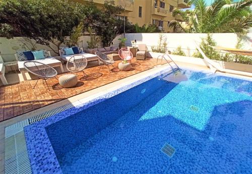 罗德镇Hotel Parthenon Rodos city的一个带椅子和桌子的大型游泳池