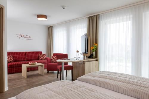 布尔库勒斯恩格尔酒店的酒店客房,配有一张床和一张红色的沙发