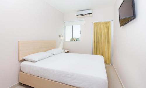 里奥阿查Ribai Hotels -Riohacha的一间白色卧室,配有床和电视