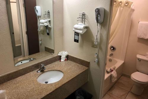安大略安大略速8酒店的一间带水槽和卫生间的浴室以及一部电话