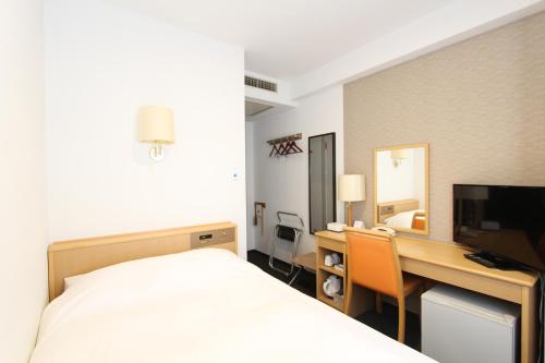 米泽市HOTEL BB fast Yonezawa的酒店客房配有一张床和一张带电脑的书桌