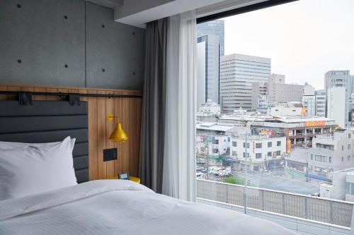 名古屋ibis Styles Nagoya的一间卧室设有一张床和一个大窗户