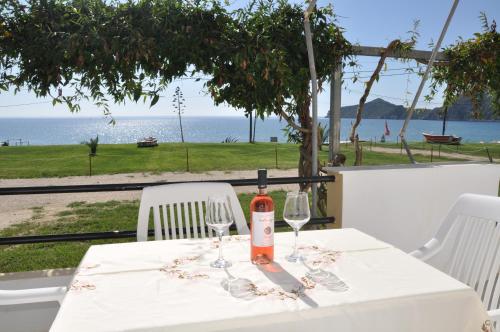 圣佐治欧斯帕贡ELIAS & VASILI HOUSE的一张桌子,上面放着一瓶葡萄酒和两杯酒