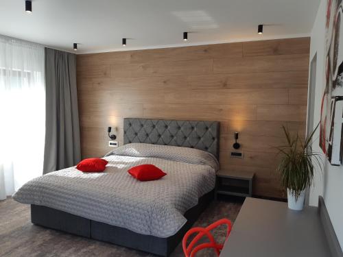 布拉索夫维拉特拉佩兹酒店的一间卧室配有一张带红色枕头的床