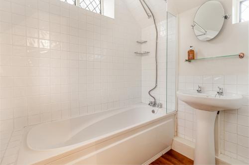 BredonGuest Homes - The Old Thatch的白色的浴室设有浴缸和水槽。