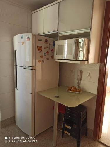 戈亚尼亚Apartamento setor bueno的小厨房配有白色冰箱和桌子