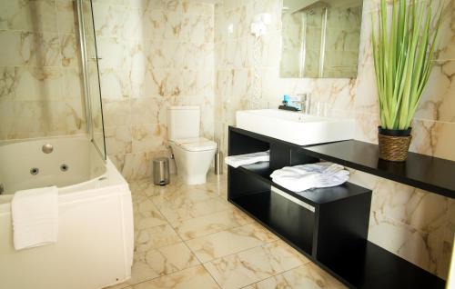 马塞杜-迪卡瓦莱鲁什穆沙舒酒店的带浴缸、盥洗盆和卫生间的浴室