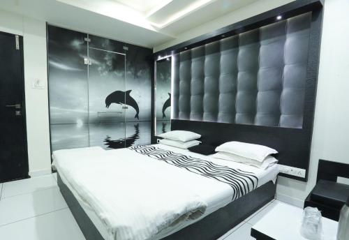 拉杰果德Hotel Paramount Inn的一间卧室配有一张大床和黑色床头板