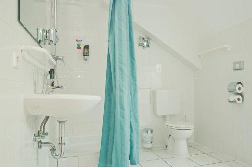 柏林Happy Hotel Berlin的白色的浴室设有水槽和卫生间。