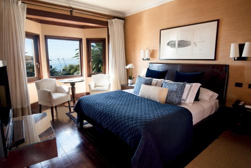 瓦尔帕莱索卡萨伊格拉斯酒店的一间卧室配有一张带蓝色棉被的床